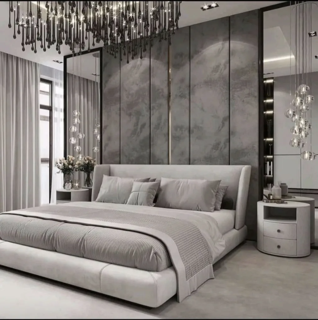A grey upholstered headboard with turned-in wings against a full-height panelled feature wall