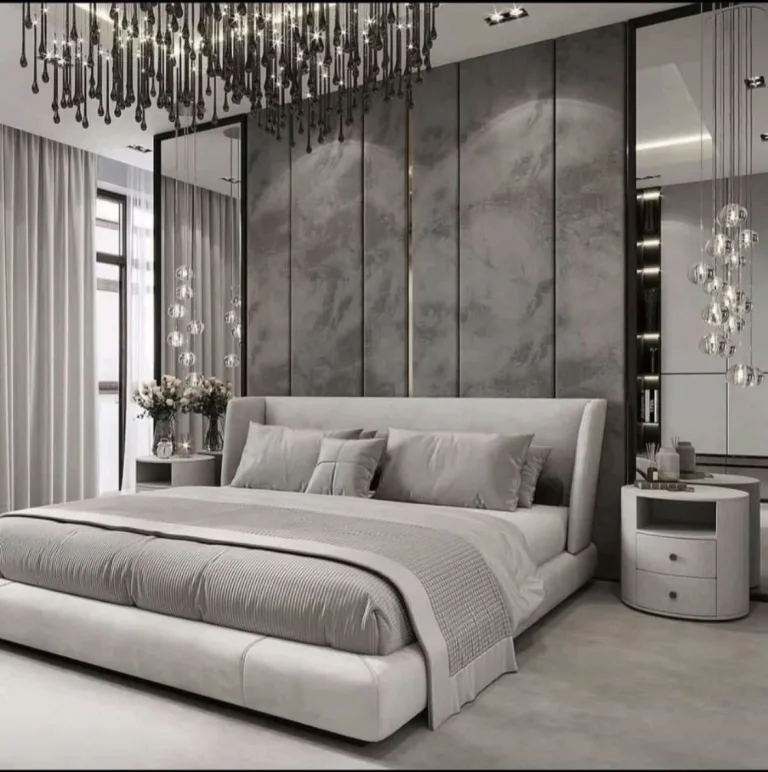 A grey upholstered headboard with turned-in wings against a full-height panelled feature wall